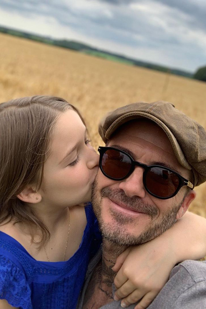 David Beckham being kissed on the cheek by his daughter, Harper Beckham