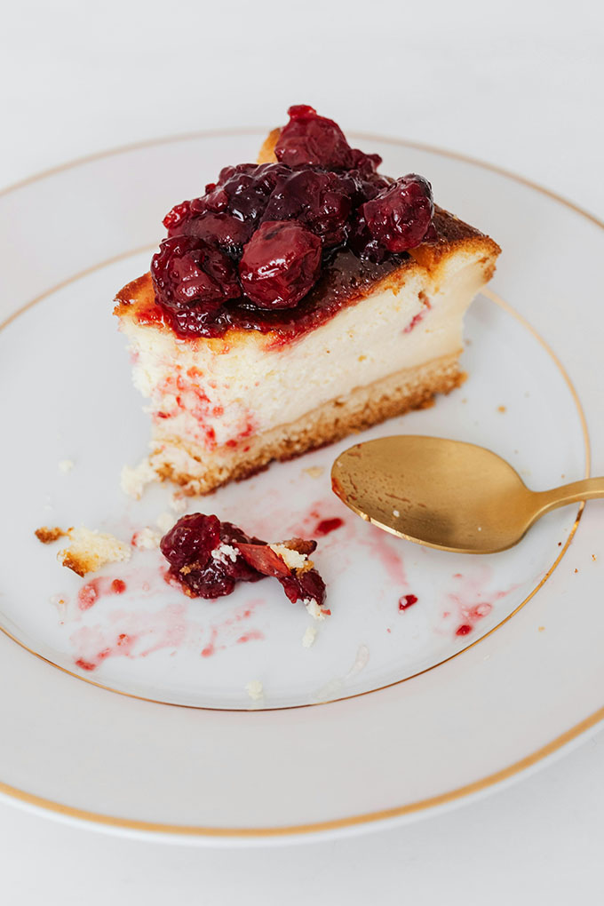 A cheesecake topped with blood-red cherries.