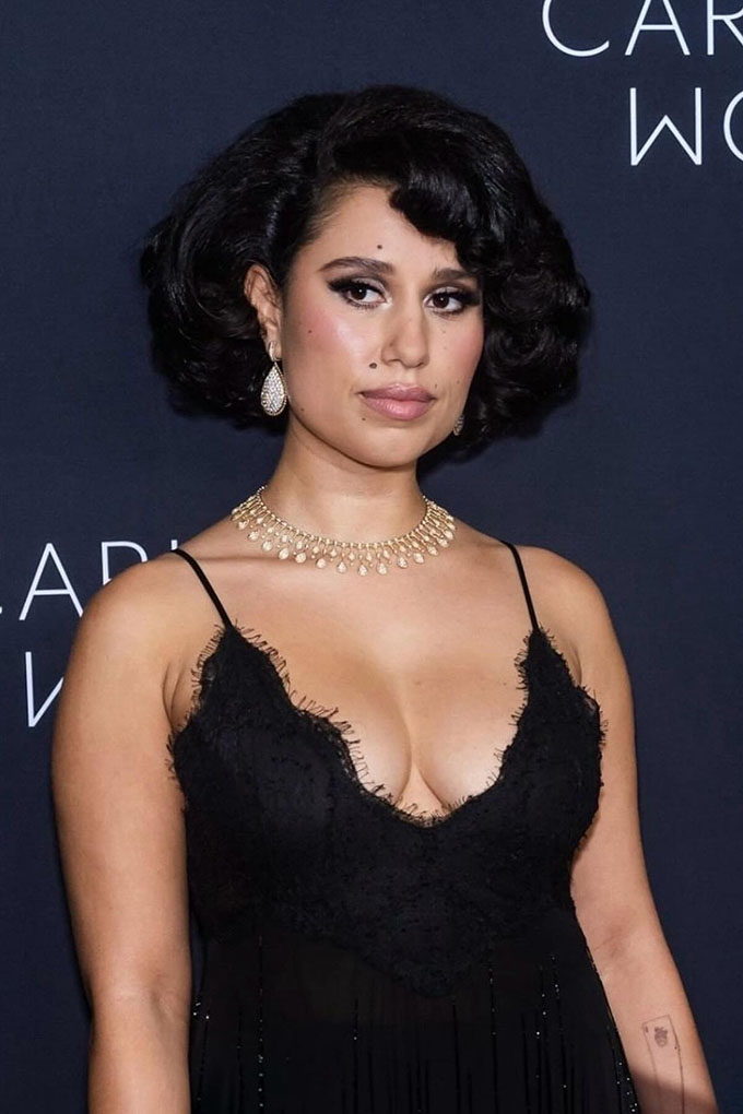 Raye at Kering Foundation's Caring for Women event in New York City. She is sporting retro Hollywood style curls, with the curls facing towards her face.