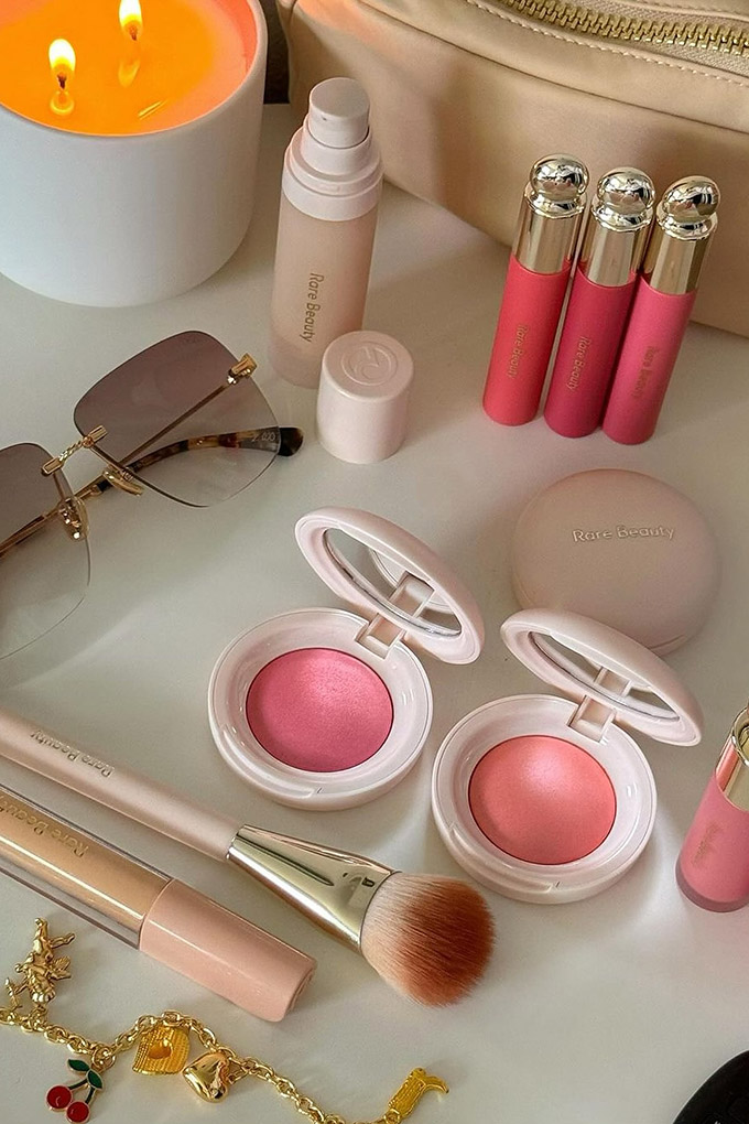 A vanity table feature products from Rare Beauty. The products are haphazardly and neatly grouped.