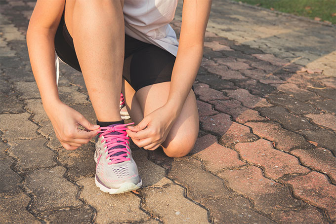 Woman Lacing Up Her Gray and Pink Athletic Shoe Exercise